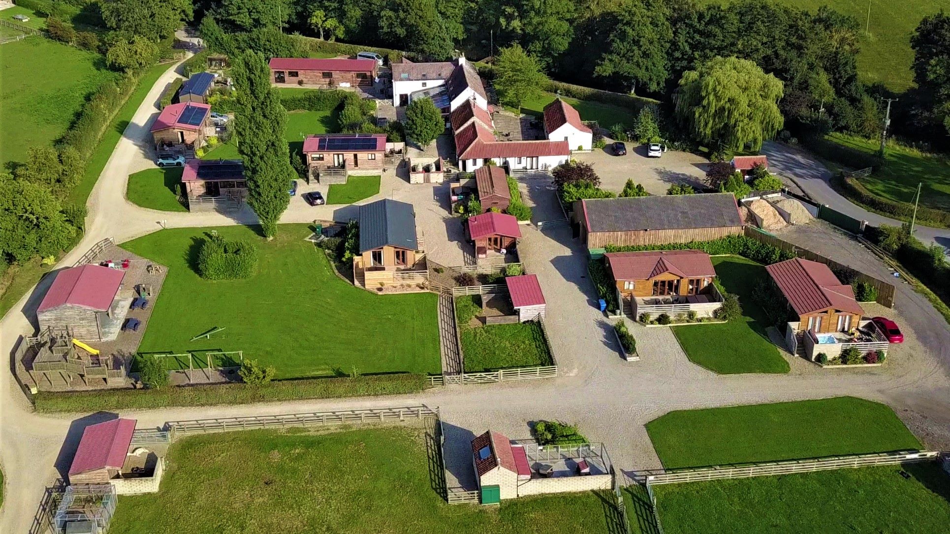 Aerial View Of Barker Stakes Farm With Buildings And Green Fields.